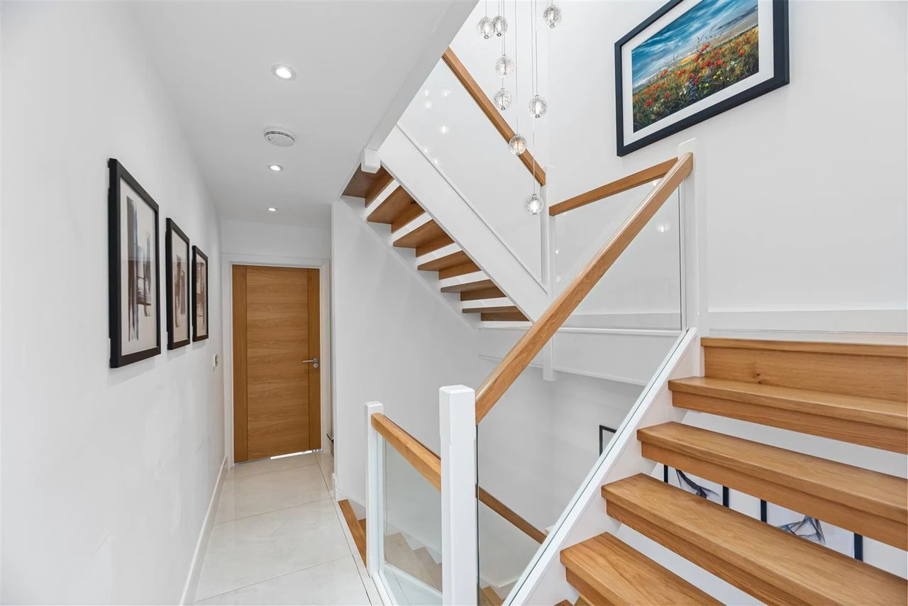 Oak and glass staircase rising through the three storeys