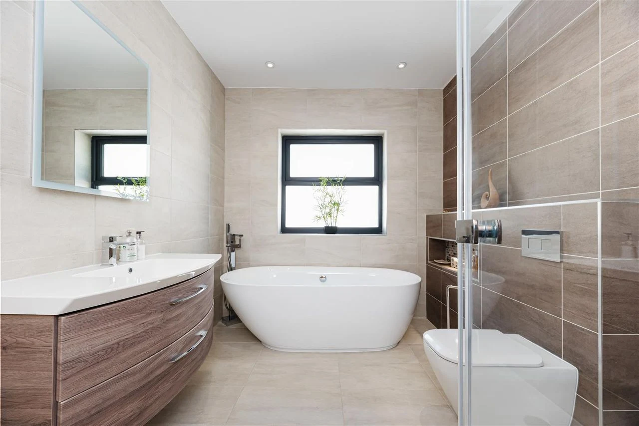 Family bathroom with a freestanding tub and stone tiling